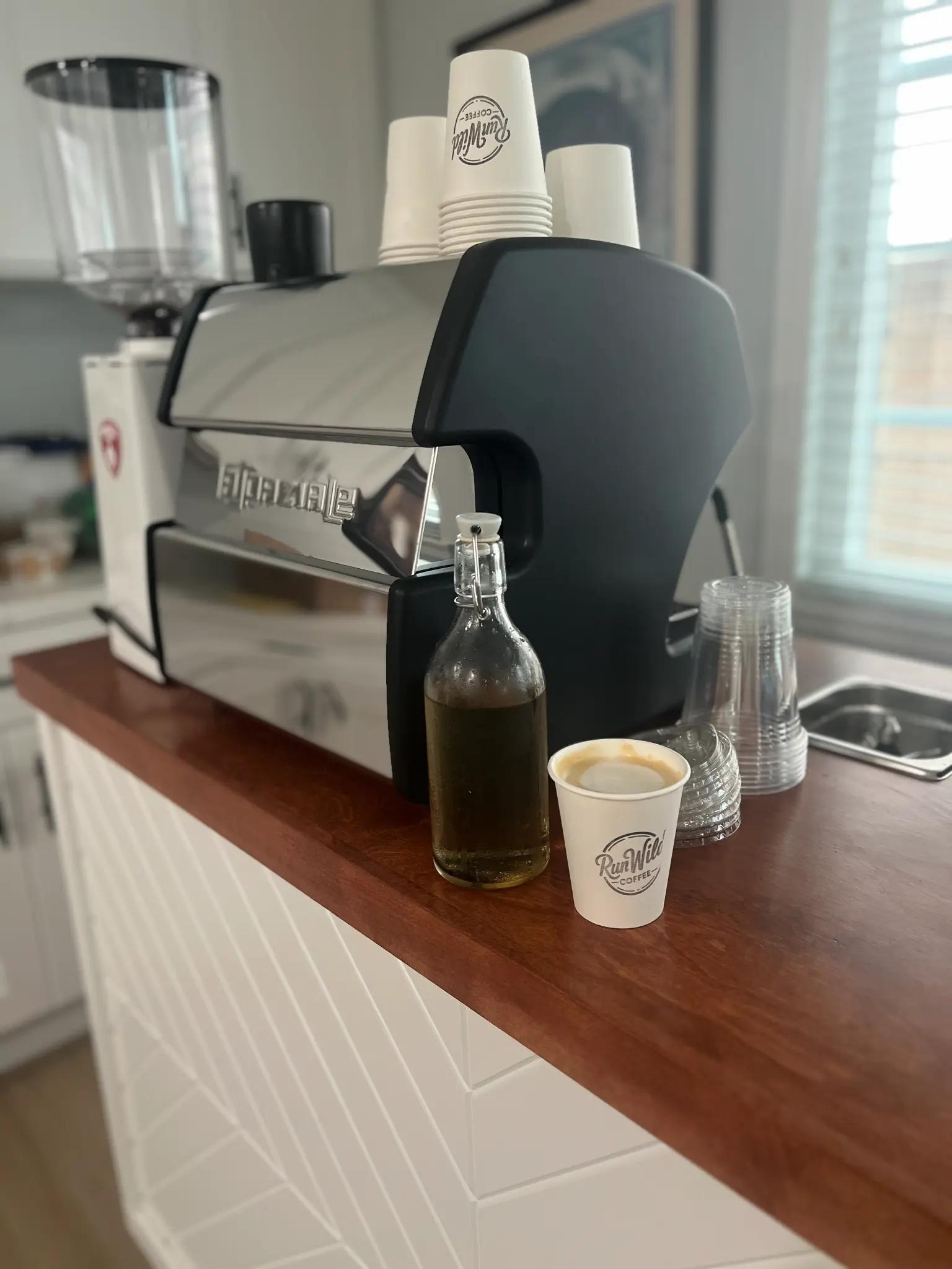 Run Wild Coffee espresso machine setup with branded cups